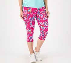 a woman wearing pink floral print capris and matching blue tank top stands in front of a white background