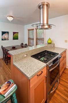 a kitchen with an island, stove and dining room table