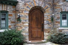 a wooden door sitting in front of a stone building