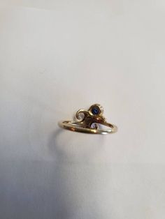 14Kt. yellow gold ring bezel set with 4mm round blue sapphire. Stone is a very nice medium blue shade. Size 5 1/4. Designed and handcrafted by Richelle Leigh using the lost wax casting process. Free shipping US. https://www.etsy.com/shop/RichelleJewelry Gold Sapphire Rings With Round Stone, Unique Yellow Gold Sapphire Ring With Accent Stones, Unique Gold Sapphire Ring In Sterling Silver, Unique Yellow Gold Sapphire Ring With Bezel Setting, Blue 14k Gold Hallmarked Birthstone Ring, Sapphire Birthstone Ring In 14k Gold, 14k Gold Spiral Jewelry For Anniversary, Blue 14k Gold Birthstone Ring, Unique Yellow Gold Ring With Birthstone