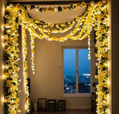 an archway decorated with yellow flowers and lights for a wedding or special occasion in the evening