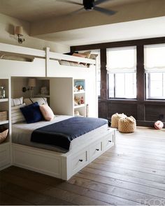 there is a bunk bed in the middle of this room with shelves on both sides