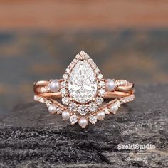 a diamond and pearl ring on top of a rock