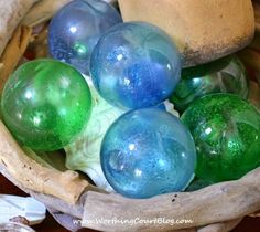 some blue and green glass balls in a basket