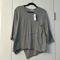 Round Neck, 3/4 Sleeves With Raw-Cut Crossover. Detailing At Front And Back With Asymmetric Hem. Cotton. Gray 3/4 Sleeve Tops For Fall, Gray 3/4 Sleeve Summer Top, Gray 3/4 Sleeve Top For Summer, Gray Summer Top With 3/4 Sleeves, Casual Gray Tops With 3/4 Sleeve, Chic 3/4 Sleeve Tops For Layering, Casual Asymmetrical Tops For Loungewear, Relaxed Fit Half Sleeve Top For Layering, Versatile Tops For Layering With 3/4 Sleeves