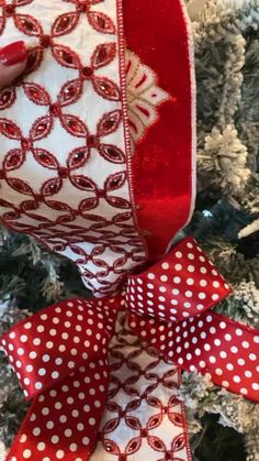 a red and white ribbon with polka dots on it next to a christmas ornament