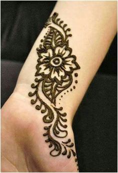 a woman's hand with a henna tattoo on it