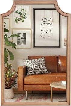 a living room filled with furniture and framed pictures on the wall above a leather couch