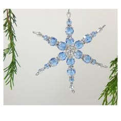 a snowflake ornament hanging from a christmas tree