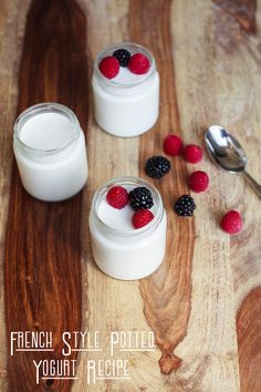 yogurt with raspberries and blackberries in small jars on a wooden table