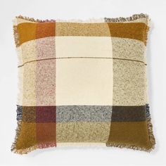 a multicolored plaid pillow with fringes on the front and back, against a white background