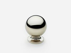 a white and black door knob on a silver plated cabinet or drawer with an oval handle