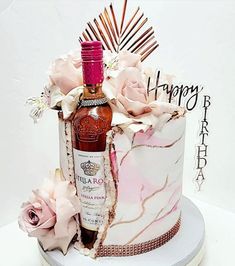 a cake decorated with flowers and a bottle of liquor