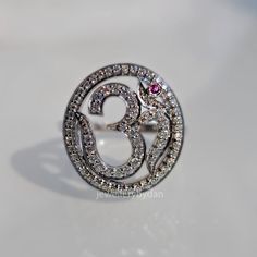 a diamond ring with the number three surrounded by smaller diamonds and garnets on it