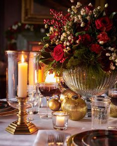 a table topped with lots of candles and vases filled with flowers