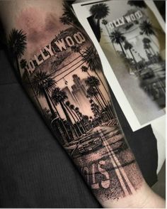 a man's arm with the hollywood sign and palm trees in black and white