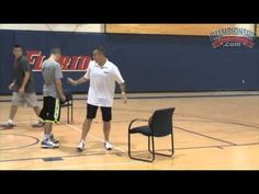 two men standing on a basketball court with one man holding the other's hand