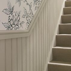 a stair case with flowers painted on the wall and carpeted steps leading up to it