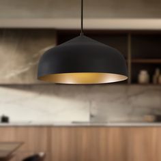 a black and gold pendant light hanging from a kitchen ceiling