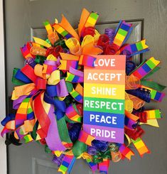 a colorful wreath that says love accept shine respect peace pride on the side of a door