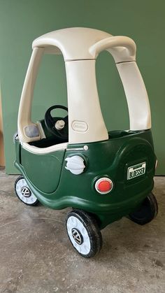 a green and white toy car sitting on top of a floor