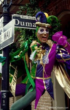 a mardi gras costumed man on the corner of dunma and duke way