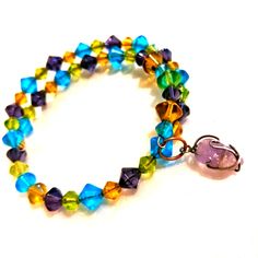 Add A Pop Of Color To Your Look With This Y2k Artisan Handmade Bracelet Featuring Yellow, Green, Blue & Purple Swarovski Crystal Beads That Glow Vivid And Bright Under Lights With A Polished Amethyst Pendant Wrapped With Silver Wire. This Bracelet Is Strung On A Metal Base Wire For Long Lasting Wear And Stretches To Fit Wrists Of All Sizes. A Perfect Accessory For Boho Hippie Chic Looks. Layer It For Extra Stylish Looks And Harness The Love Attraction Magic Of This Gemstone. Adjustable Multicolor Amethyst Bracelets, Adjustable Multicolor Amethyst Bracelet, Handmade Multicolor Amethyst Bracelets, Adjustable Amethyst Jewelry With Colorful Beads, Love Attraction, Crystal Wrap, Healing Gemstone Bracelets, Turtle Bracelet, Daisy Bracelet