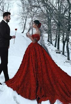 a man in a tuxedo standing next to a woman in a red dress