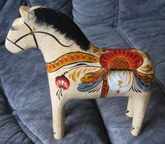 a wooden toy horse sitting on top of a bed