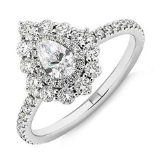 a white gold ring with an oval cut diamond surrounded by small round diamonds