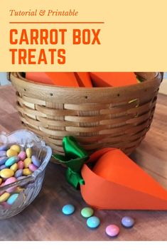 carrot box treats are sitting on a table next to a basket with candy in it