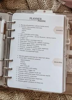 an open planner book sitting on top of a blanket