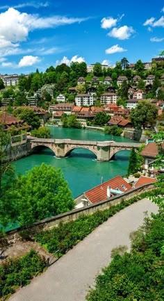 a bridge over a river next to a lush green hillside