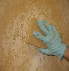 a person in blue gloves is cleaning the wall