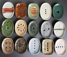 nine ceramic bowls with holes in them on a black table top, all lined up together