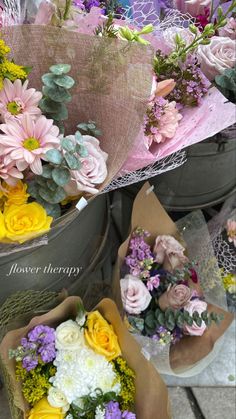 several buckets filled with different types of flowers