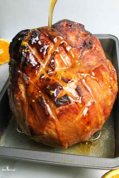 someone is pouring caramel sauce on the top of a baked pastry in a pan