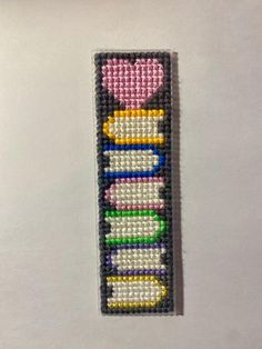 a bookmark made out of beads with a heart on top