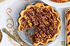 there is a pie on the table with other desserts and utensils next to it