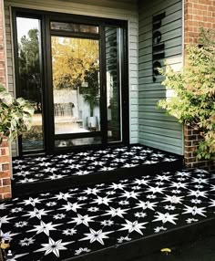 a black and white star rug on the front steps of a house