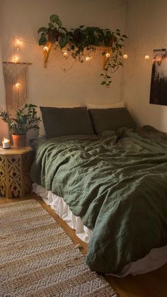 a bed with green sheets and pillows in a bedroom next to a wall mounted plant