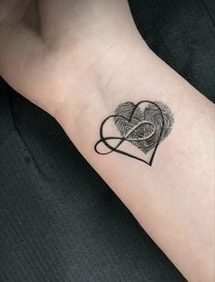 a heart with two finger prints on the side of it and an intertwined ribbon