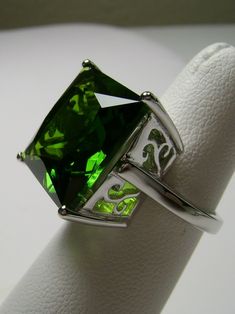 Simulated Green Peridot Ring Description Square Design#45 MADE TO ORDER This is a brand new Art Nouveau/Victorian styled sterling silver filigree ring. This Flawless high-quality Man-made/Simulated square-cut Green Peridot is 15mm (about 9/16th of an inch) in length and 15mm in width. The over 12ct square gem is just captivating; it is a stunning and comfortable ring to wear. The inside of the band is marked 925. Notice the beautiful swirl/heart like the craftsmanship of the silver filigree sett Green Gemstone Ring For Formal Occasions, Elegant Green Ring With Large Stone, Elegant Green Rings With Large Stone, Green Crystal Ring With Prong Setting For Formal Events, Elegant Green Peridot Crystal Ring, Classic Green Jewelry With Large Stone, Green Sterling Silver Crystal Ring For Formal Occasions, Green Crystal Sterling Silver Ring For Formal Occasions, Green Hallmarked Crystal Ring For Anniversary