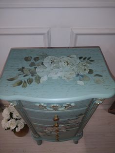 an ornate blue chest with flowers painted on it