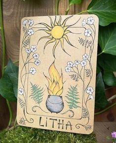 a card with an image of a pot on fire in front of flowers and leaves