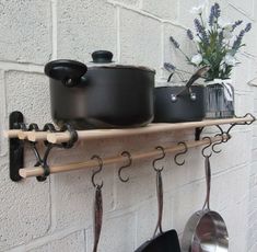 pots and pans are hanging on the wall next to each other with hooks attached