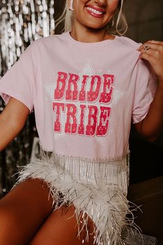 Celebrating an engagement? Your bride tribe just got a whole new favorite tee! -Soft cotton blend tee with a fun bold graphic "Bride Tribe" screen print on the front - Crew neckline with short sleeves -Relaxed silhouette that ends in a rhinestone fringe hemline Measurements S : Bust 40", Hip 39", Length 16", Sleeve Length 8", Waist 40". M : Bust 42", Hip 41", Length 17", Sleeve Length 8.5", Waist 42". L : Bust 46", Hip 44", Length 18", Sleeve Length 9", Waist 46". Pink Rhinestone Fringe Crop Top, Tassel Top, Rhinestone Fringe, Pink Bride, Bride Tribe, Hip Length, Screen Print, Crew Neckline, Screen Printing