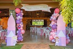 a decorated entrance to a small party with balloons and princess castle decorations on the side