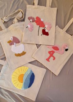 four embroidered bags with flamingos on them