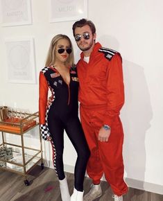 a man and woman dressed up in racing gear posing for a photo with glasses on